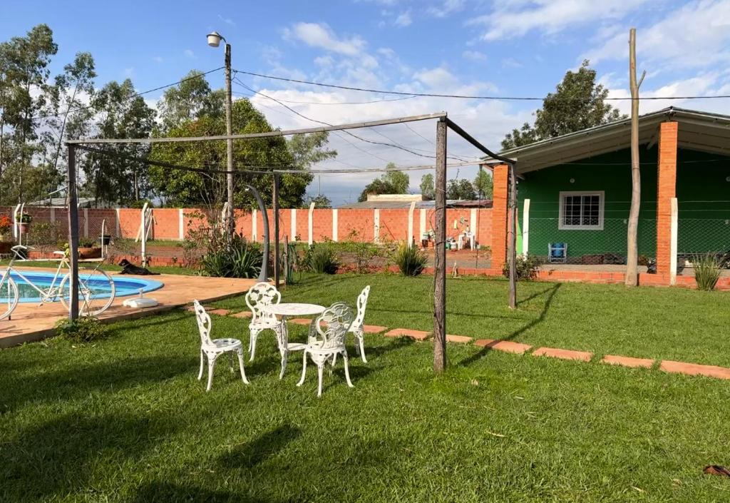a patio with four chairs and a table in a yard at Casa Verde in Mbocayaty