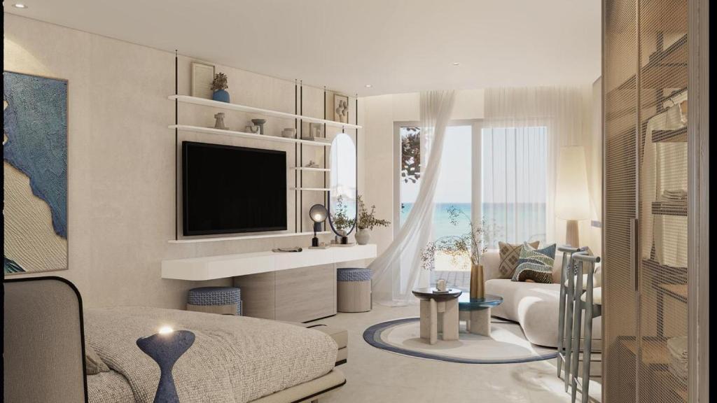 a living room with a bed and a television at U North Coast in Sidi Kirayr