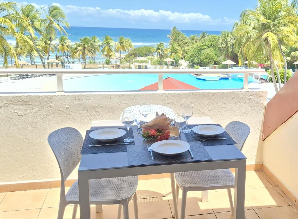 a dining table with a view of the beach at TI MAD vue mer in Sainte-Anne