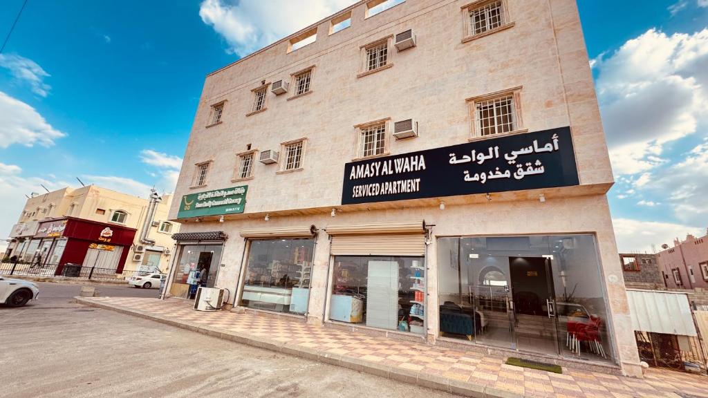 a building with a sign on the side of it at شقق أماسي الواحة بالعقيق in Al ‘Aqīq