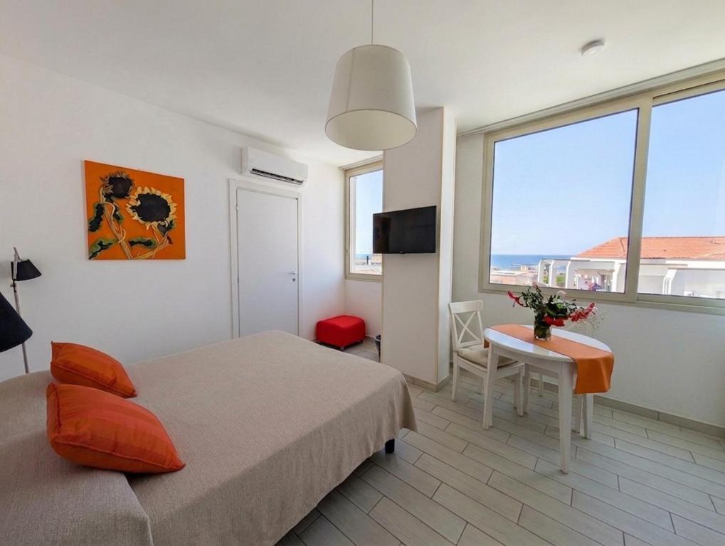 a bedroom with a bed and a table and a window at Attico al Centro in Cefalù