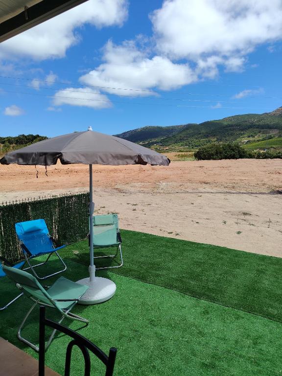 two chairs and an umbrella on the beach at Casa do Valinho 