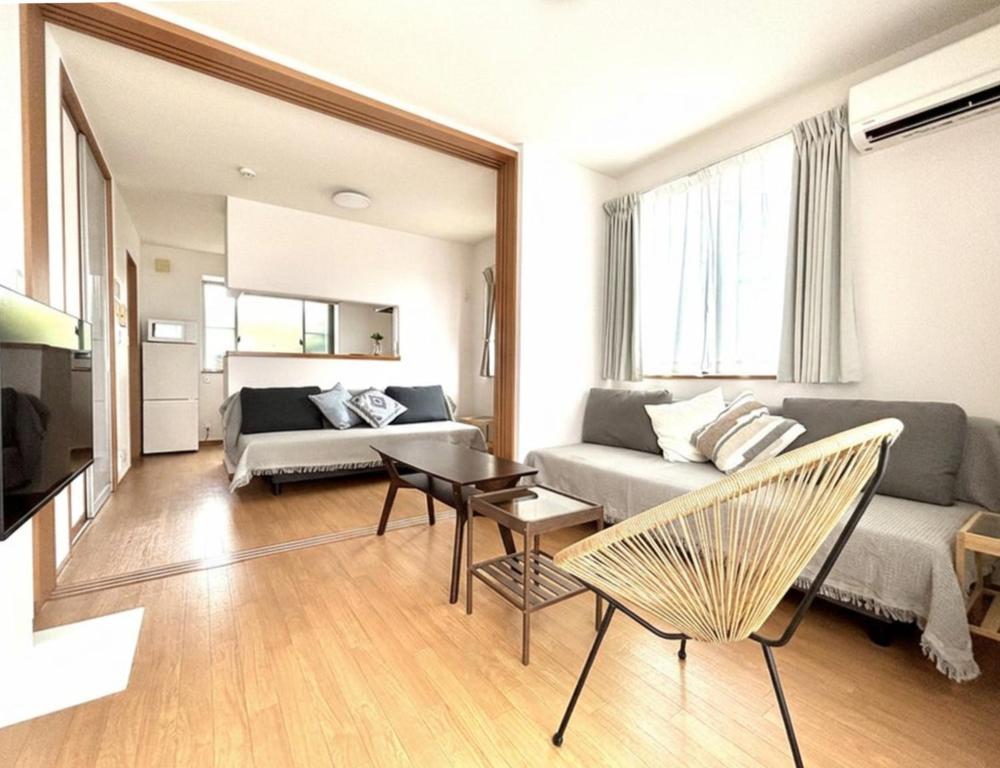 a living room with a couch and a table and chairs at 湘南で暮らすように泊まる一棟貸し U-house Shonan in Fujisawa