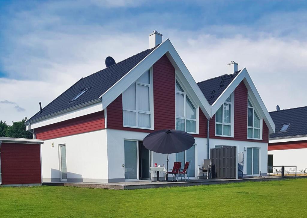 a red and white house with an umbrella at Ferienhaus Klabautermann 53 - Nordhorn in Nordhorn