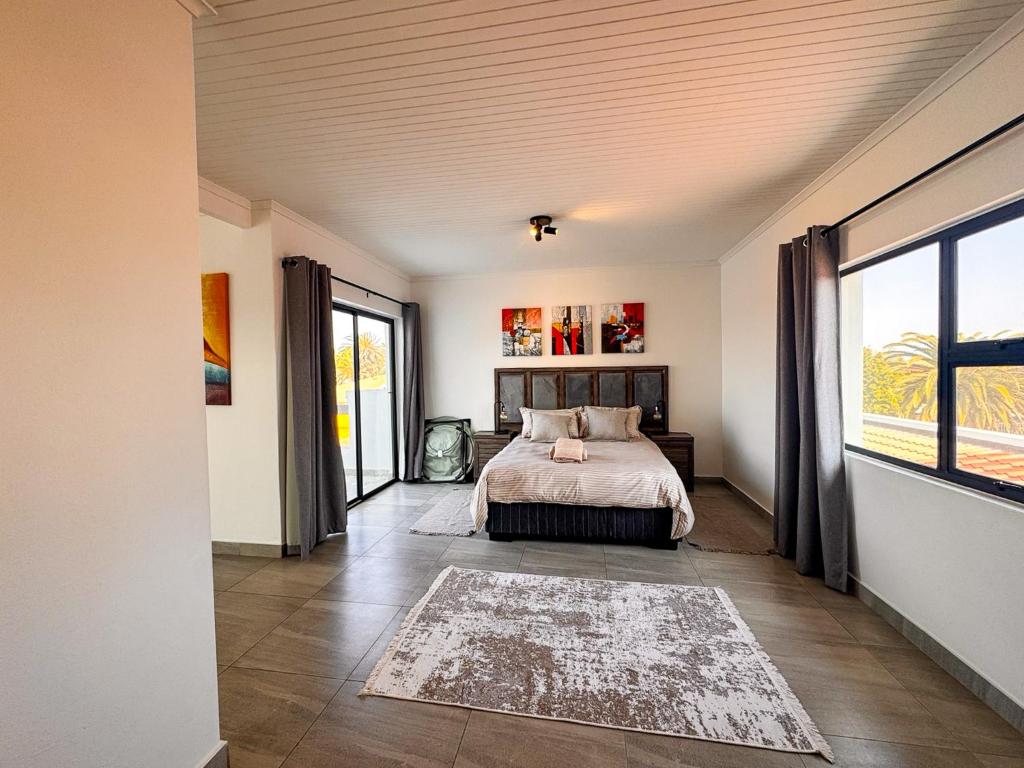 a bedroom with a bed and a large window at House Sworyx in Walvis Bay
