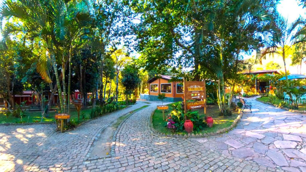 a cobblestone street in a park with trees at Villaflor Pousada in Vale do Capao