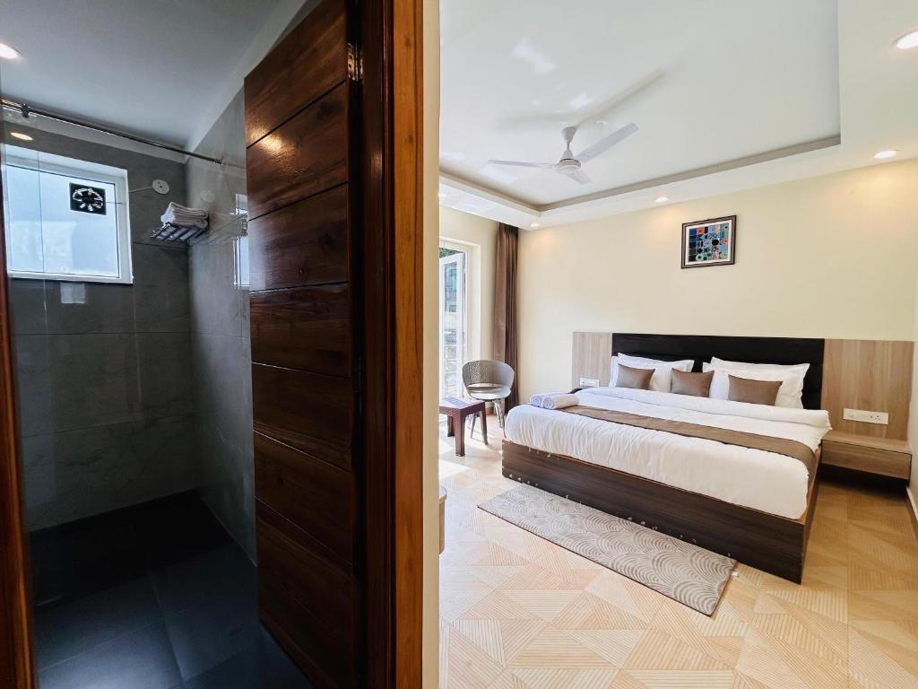 a bedroom with a bed and a walk in shower at Pranav Resort in Nainital