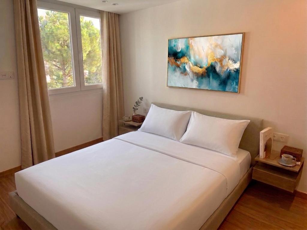 a bedroom with a white bed and a painting on the wall at Riverside Studio Joinville-Le-Pont in Joinville-le-Pont