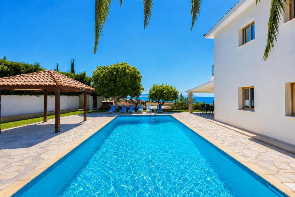 a swimming pool in front of a house at Argaka Sunset Villa in Argaka
