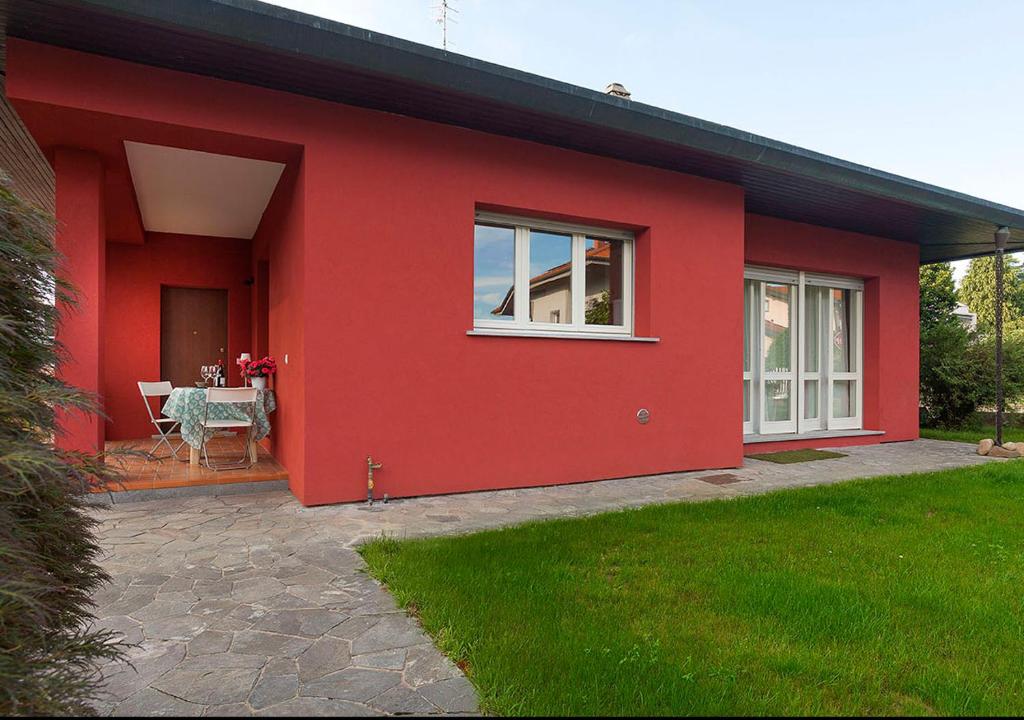 a red house with a table in front of it at Maison Rouge in Besnate
