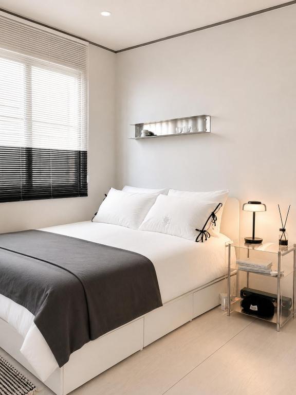 a white bedroom with a large bed and a window at Yoonsul Gwangalli 3beds for 4guests in Suyŏng