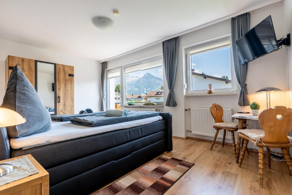 a bedroom with a bed and a table and chairs at Ferienhaus Bergverbunden in Fischen