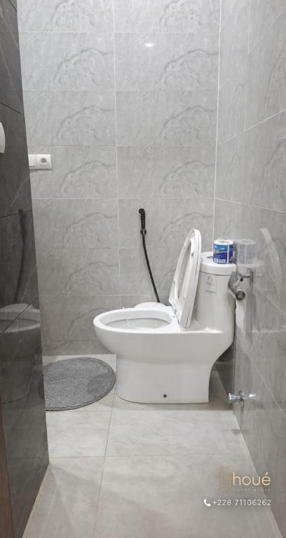 a bathroom with a white toilet in a room at Résidence Houé in Lomé