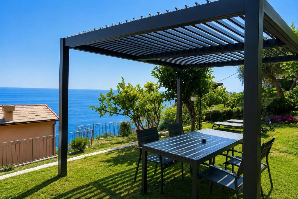 a pergola with a table and chairs on a yard at Marilú vista mare con giardino in Genoa