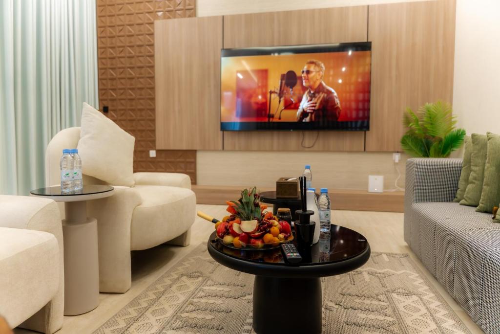 a living room with a tv and a table with fruit on it at منتجع ليورا ــ Liora Resort in Al Ḩanī