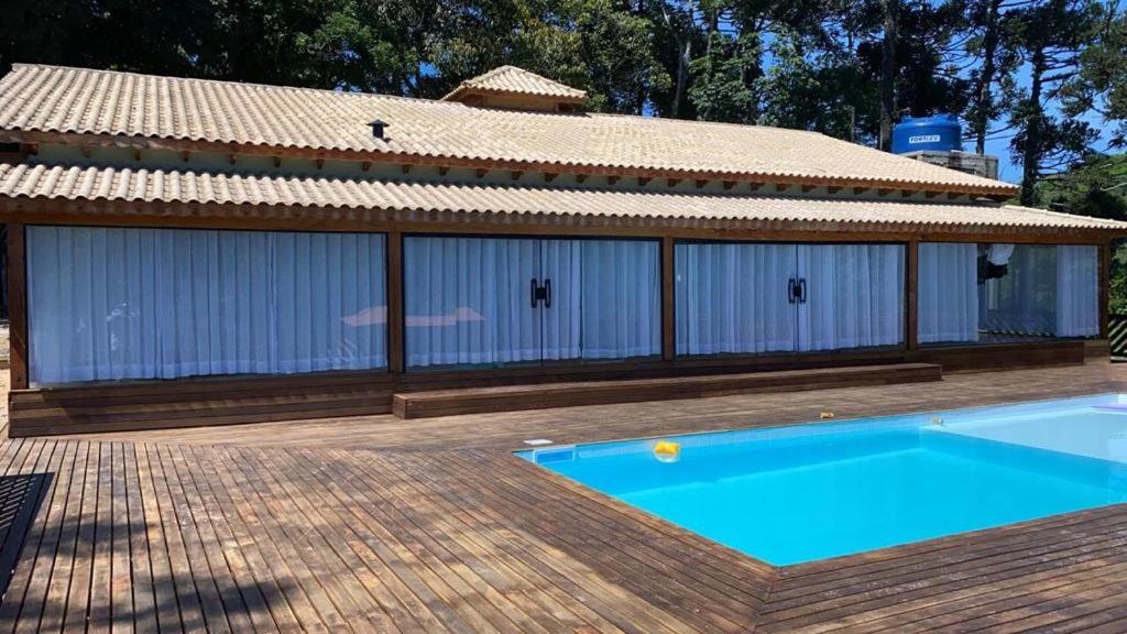 a house with a swimming pool next to a building at Chácara sabor de Mel in Ibiúna