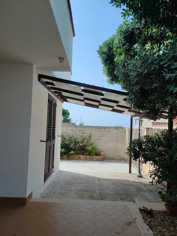 an open door of a white building with awning at Villa Cristina in Triscina
