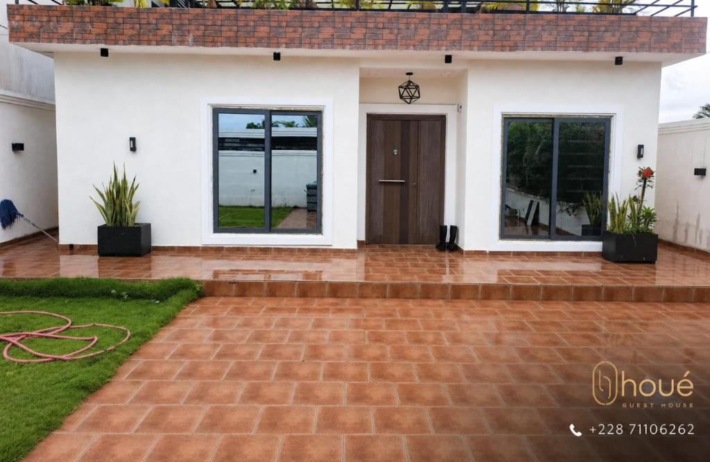 a house with a brick driveway in front of it at Résidence Houé 