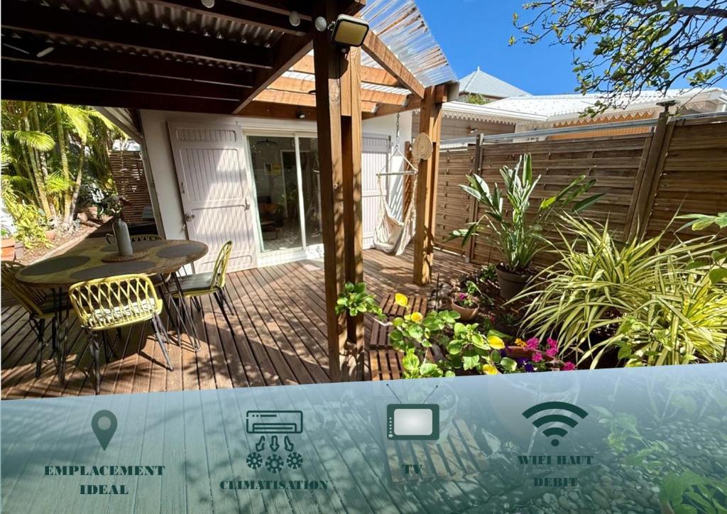 a patio with a table and chairs on a deck at Bungalow Tec-Tec Proche plage et centre Saint Leu in Saint-Leu