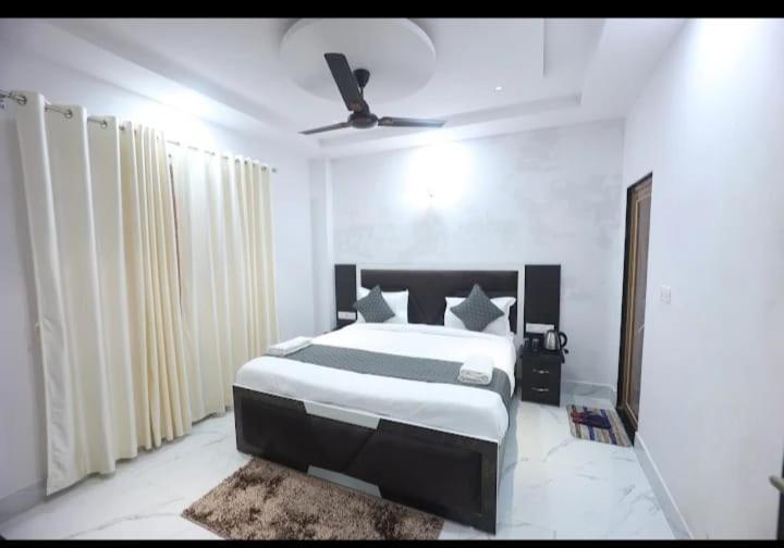 a bedroom with a bed and a ceiling fan at Hotel Prabhawati Palace Near Railway Station and Sri Vishwanath Temple Varanasi in Varanasi