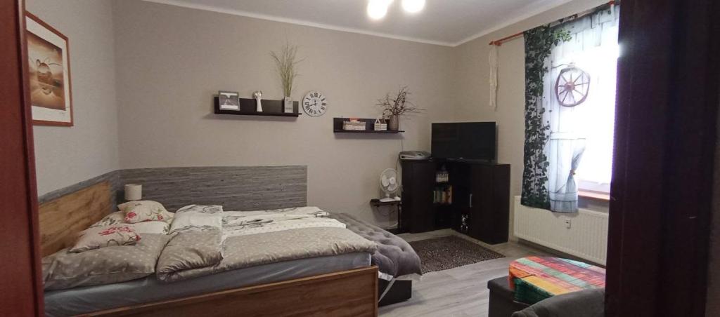 a bedroom with a bed and a window with a clock at Kawalerka u Megi in Borne Sulinowo