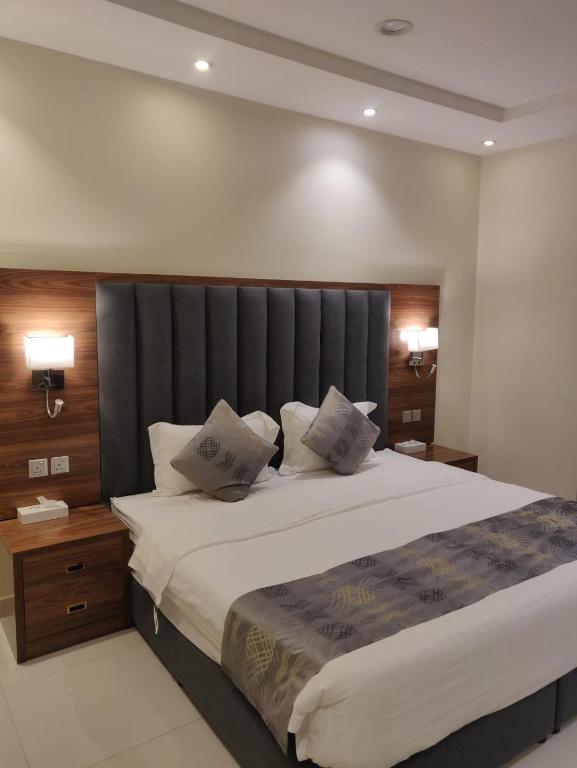 a bedroom with a large bed with a gray headboard at ايار للشقق المخدومة 1 in Riyadh