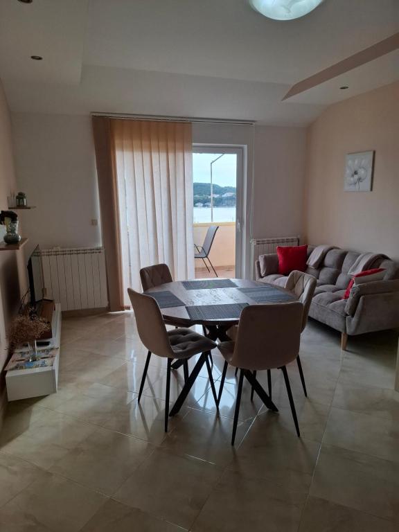 a living room with a table and chairs and a couch at More in Rab