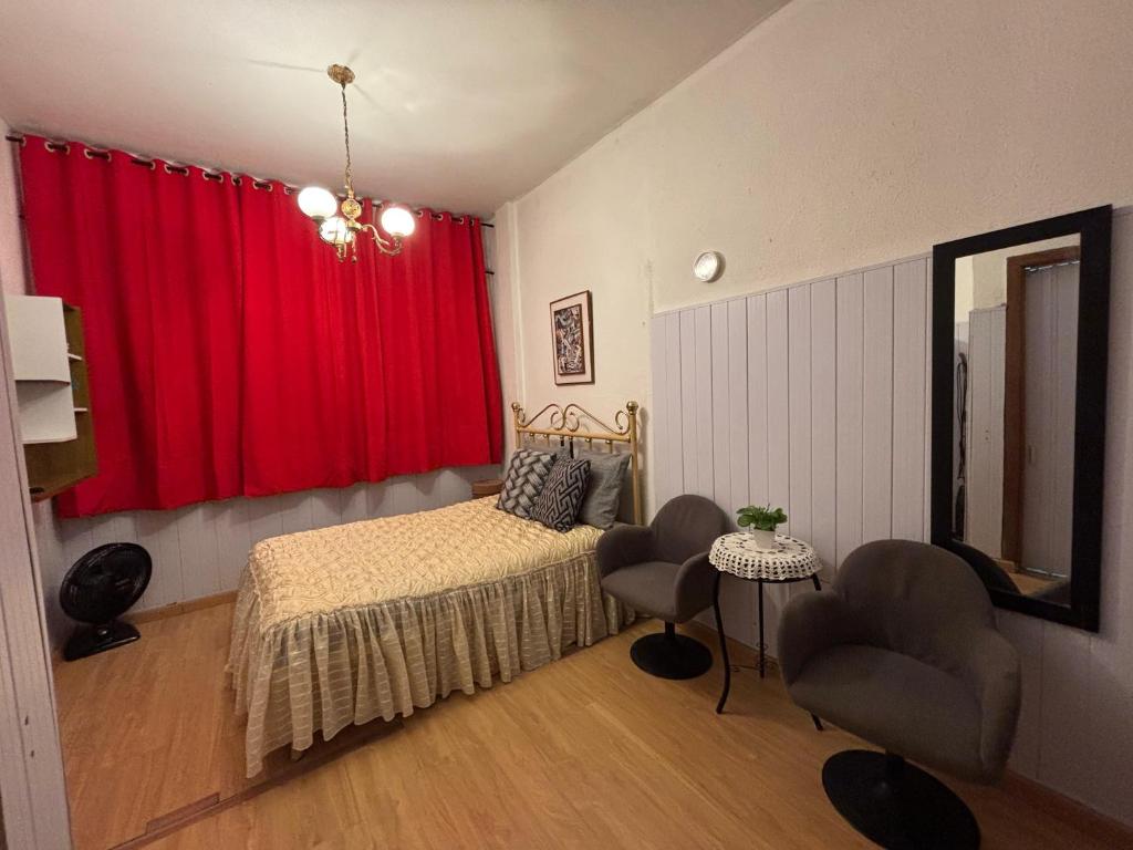 a bedroom with a bed and a red curtain at Apartamento para duas pessoas com cama de casal in Teresópolis