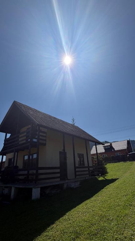 a small house with the sun in the sky at Vacation home E in Borsec