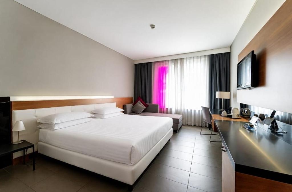 a hotel room with a large bed and a desk at Cosmopolitan Hotel in Civitanova Marche