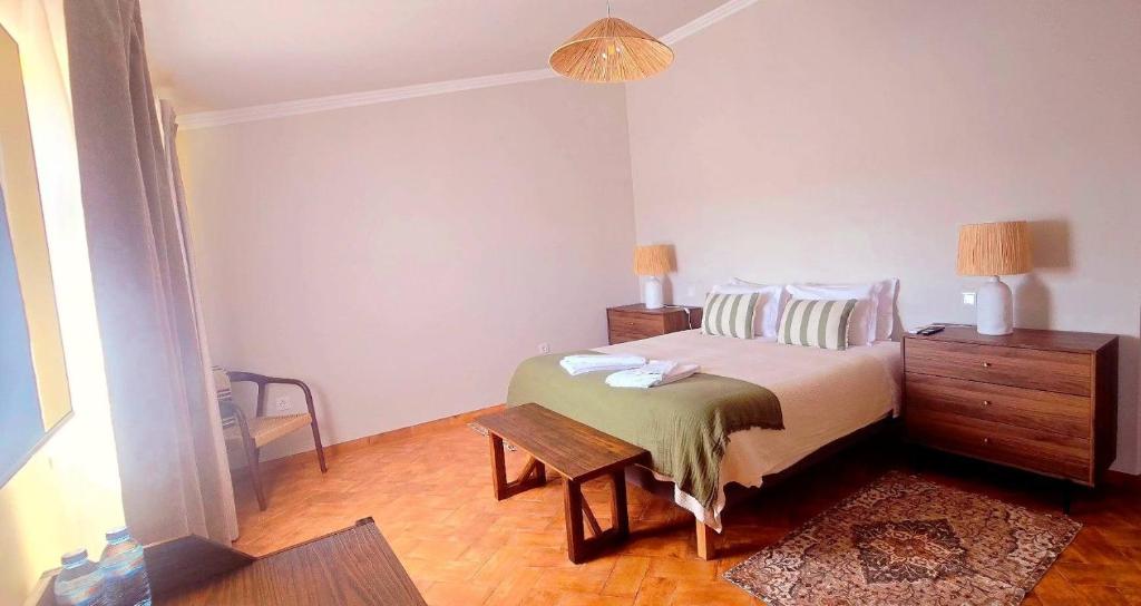 a bedroom with a bed and a table in it at Casas do Monte I - T3 