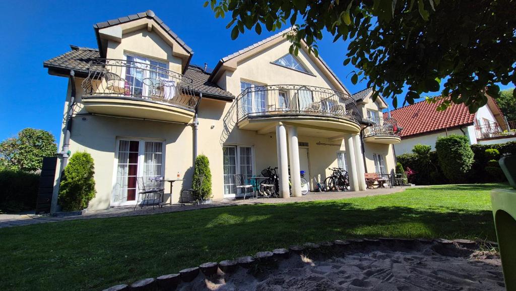 a house with two balconies and a yard at Villa Maritima in Grzybowo