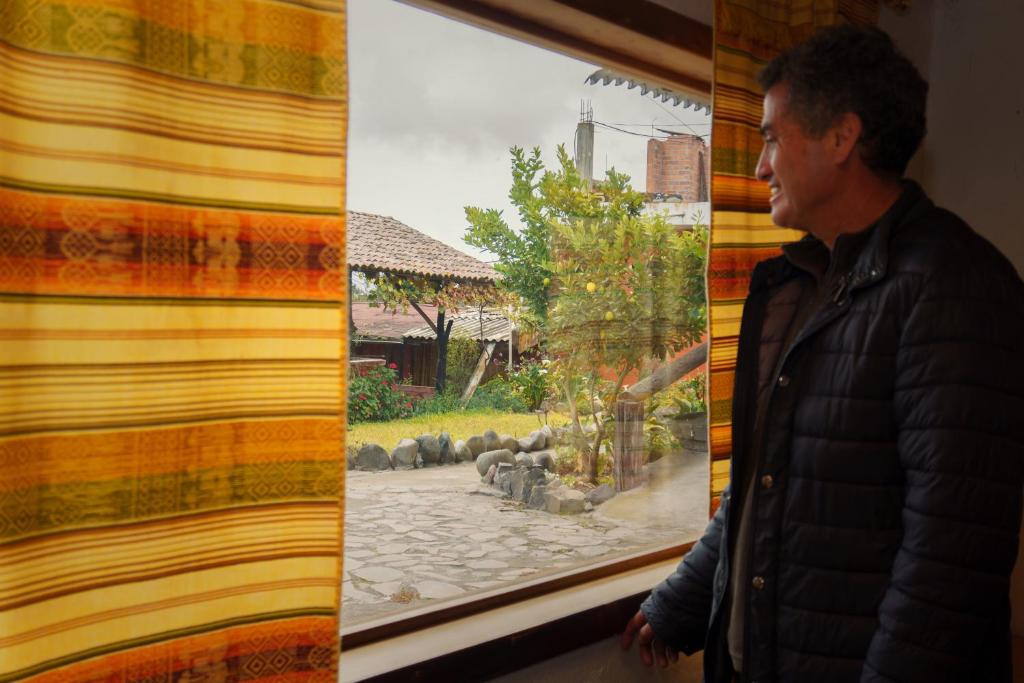a man looking at a painting on a wall at PatulomaEscape in El Rosario