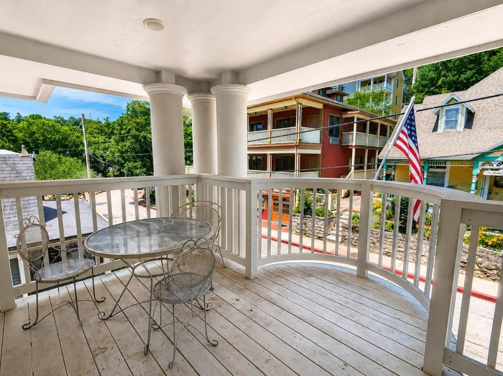 a porch with a table and chairs and a flag at Springs WishDowntown Historic Loop Downstairs King Free Parking in Eureka Springs