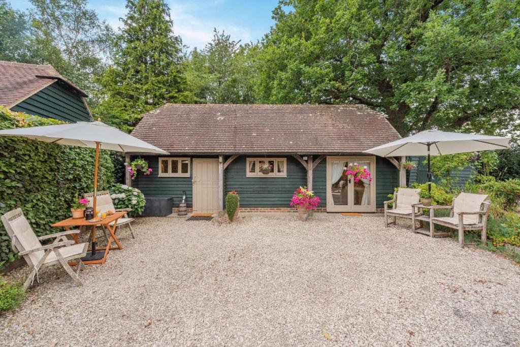 a patio with chairs and umbrellas in front of a house at 1 Bed in Battle oc-bt112 in Battle