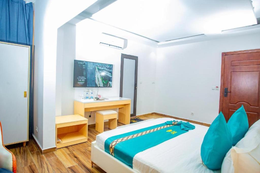 a bedroom with a bed and a desk in it at Cinq Cent Vingt Hotel & Residence in Abidjan