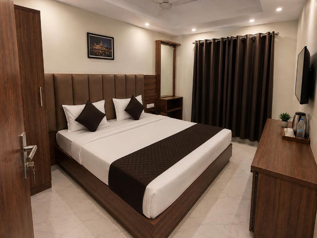a bedroom with a large bed with black curtains at Velora hotele in Amritsar