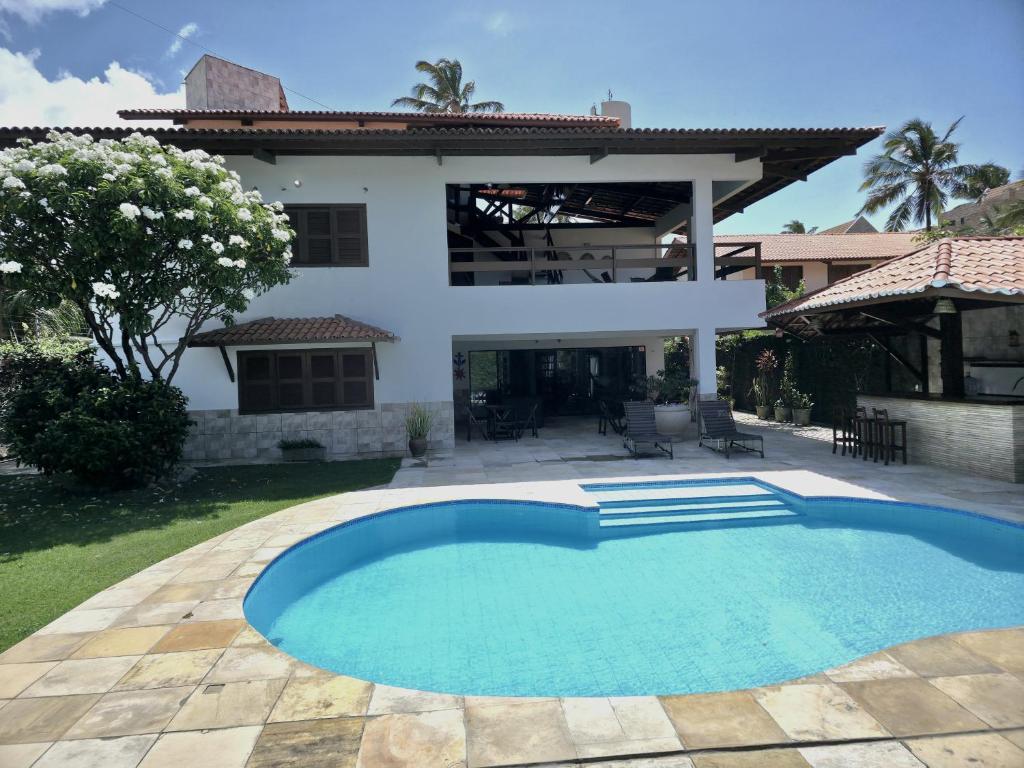 a swimming pool in front of a house at Ventos e Dunas Cumbuco in Cumbuco