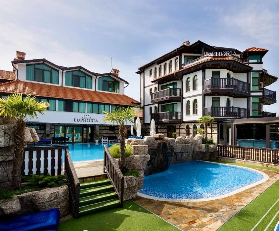 a hotel with a swimming pool in front of a building at Villa EUPHORIA in Ridovo