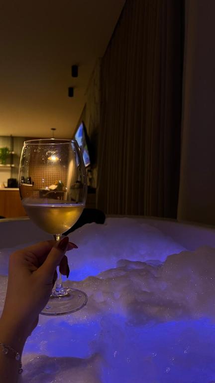 a person holding a glass of wine on a table at Cabana No Lago in Rancho Queimado