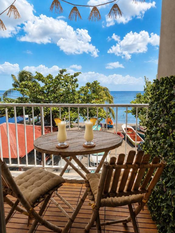 a table and chairs on a balcony with a view of the ocean at STUDIO PIEDS DANS L EAU A SCHOELCHER in Schœlcher