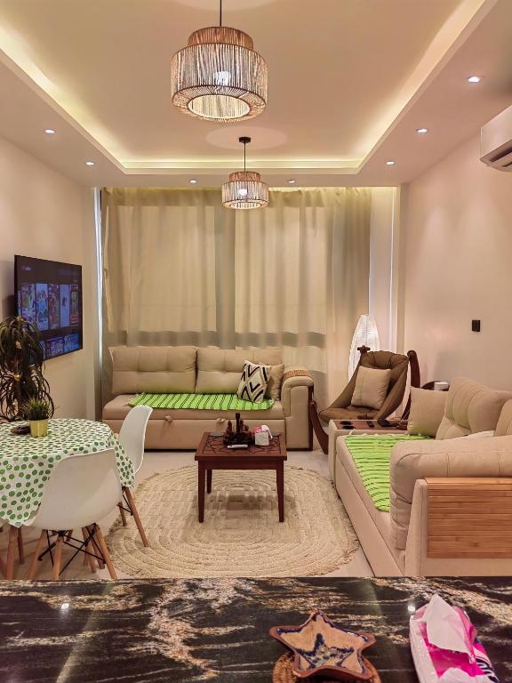 a living room with a couch and a table at Zahra-Northed Chalet in El Alamein