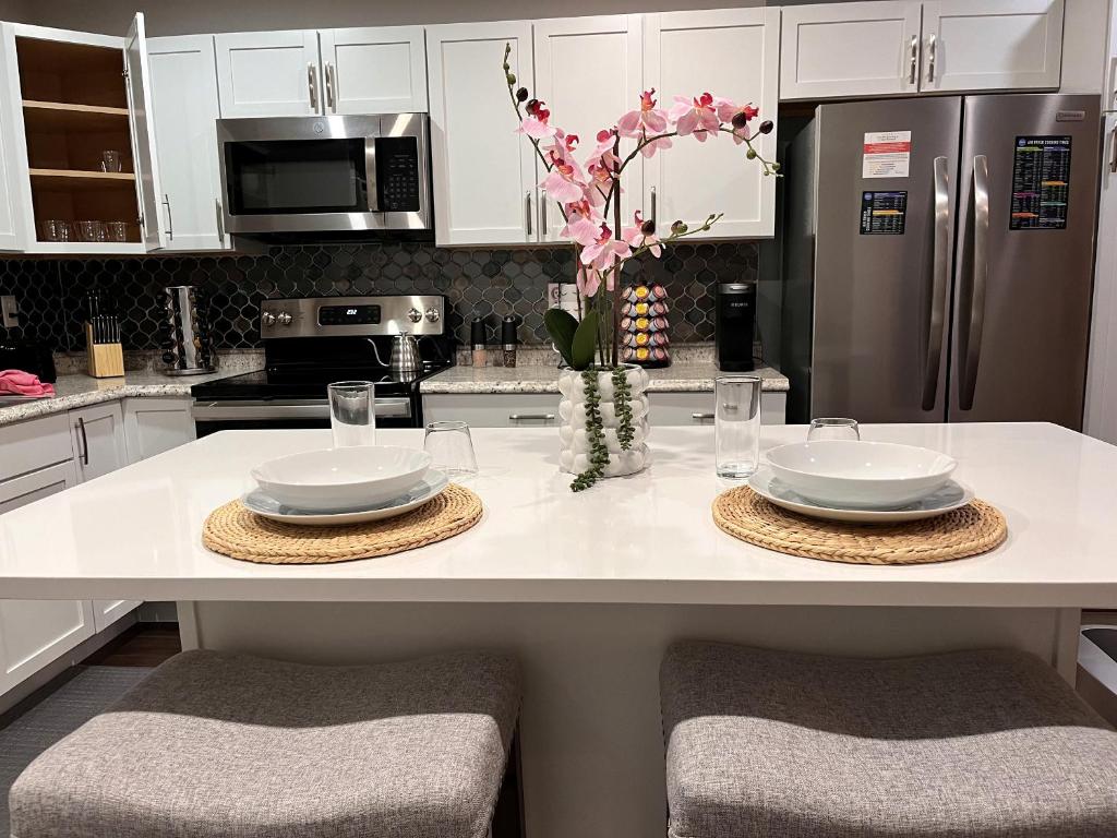 a kitchen with a counter with two plates and a refrigerator at Healing Haven King Bed Suite in Dallas