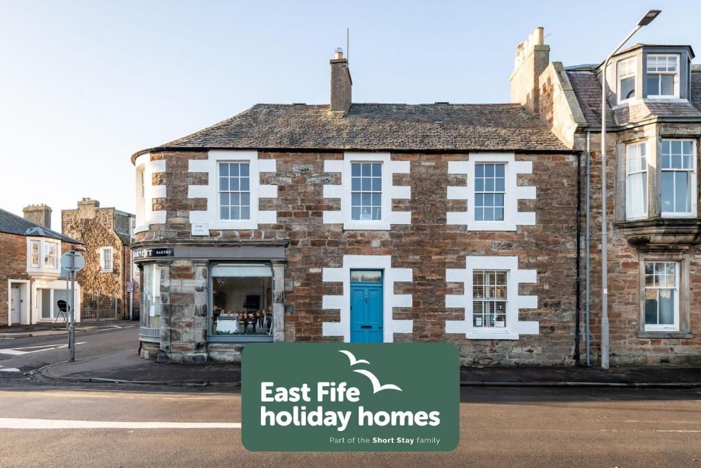 aneat life holiday homes sign in front of a building at Corner House - Elie & Earlsferry in Elie