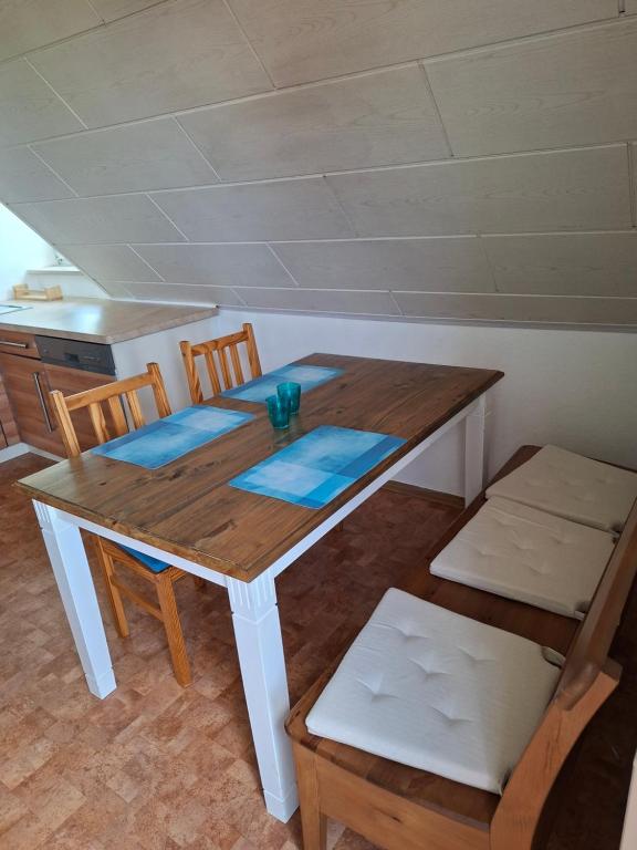 a wooden table with two chairs and a table and a kitchen at Ferienwohnung am Vogelsteig in Pegnitz