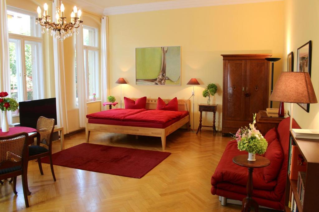 ein Wohnzimmer mit einem roten Sofa und einem roten Stuhl in der Unterkunft Elbvilla Dresden in Dresden