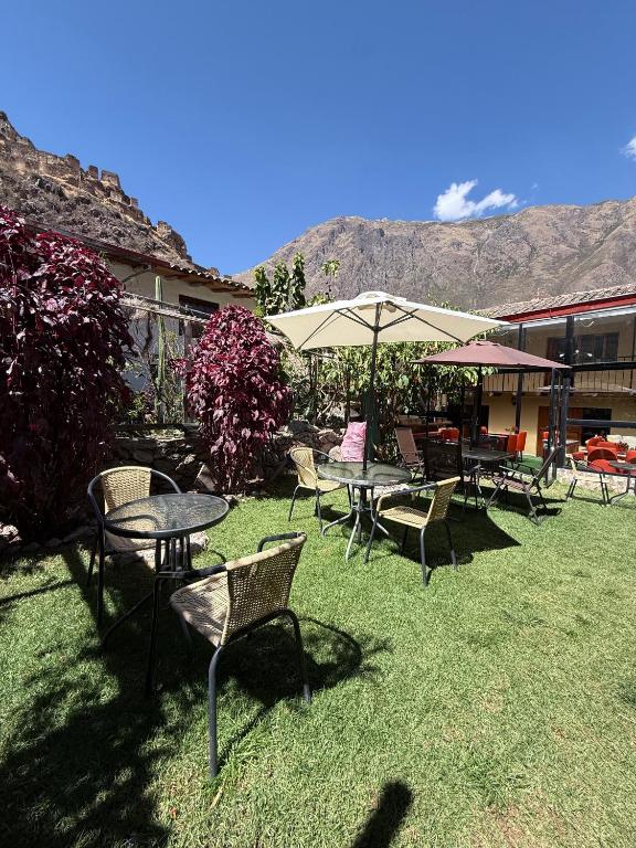 a group of tables and chairs and an umbrella at Anido House in Ollantaytambo