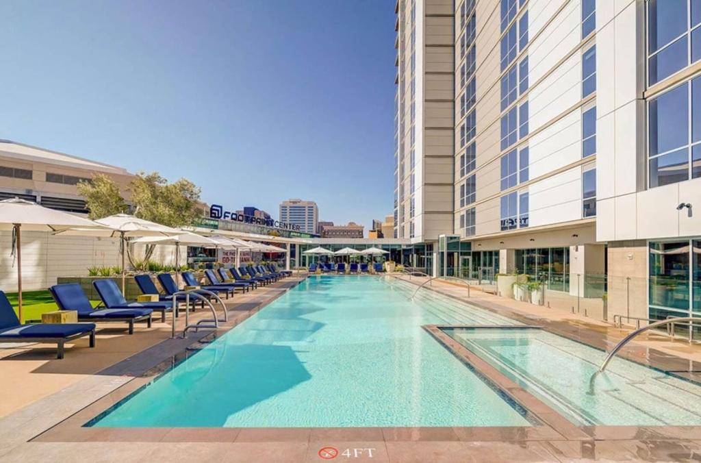 a large swimming pool with chairs and a building at CozySuites at Adeline in Phoenix