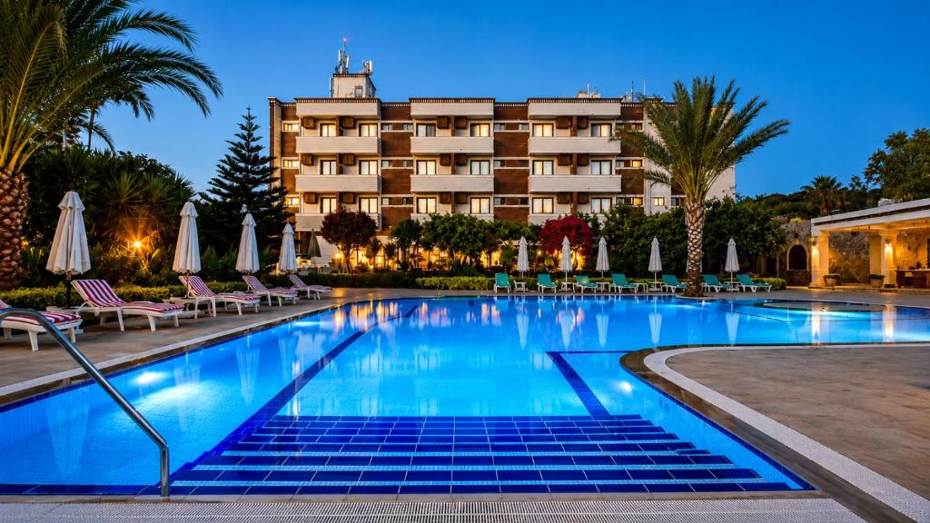 a hotel with a swimming pool in front of a hotel at ANADOL Hotel & Pool Central Kyrenia in Temblos