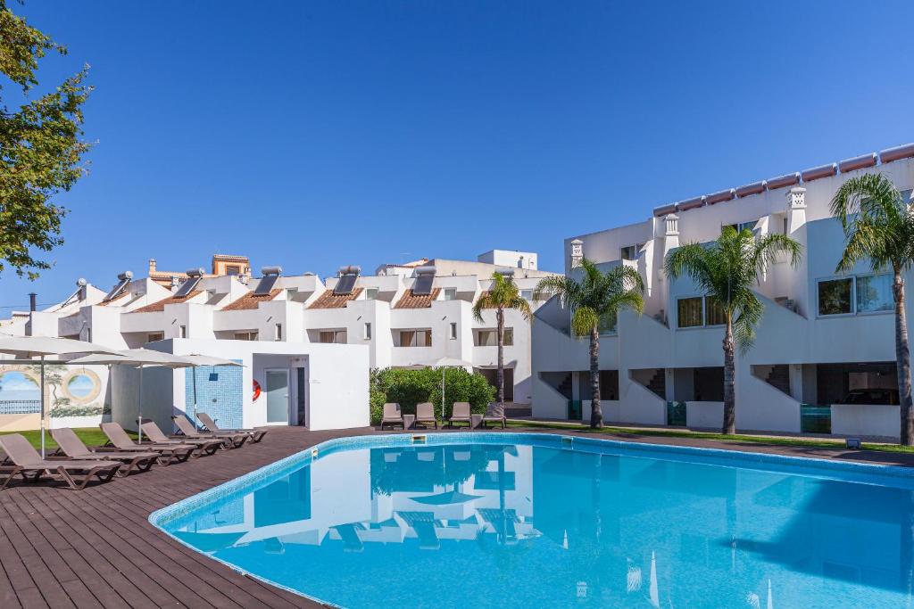 a swimming pool in front of a building at Lagoa Hotel in Lagoa